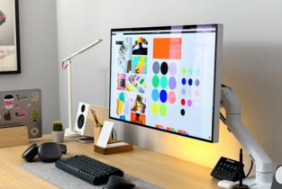 a computer monitor sitting on top of a wooden desk